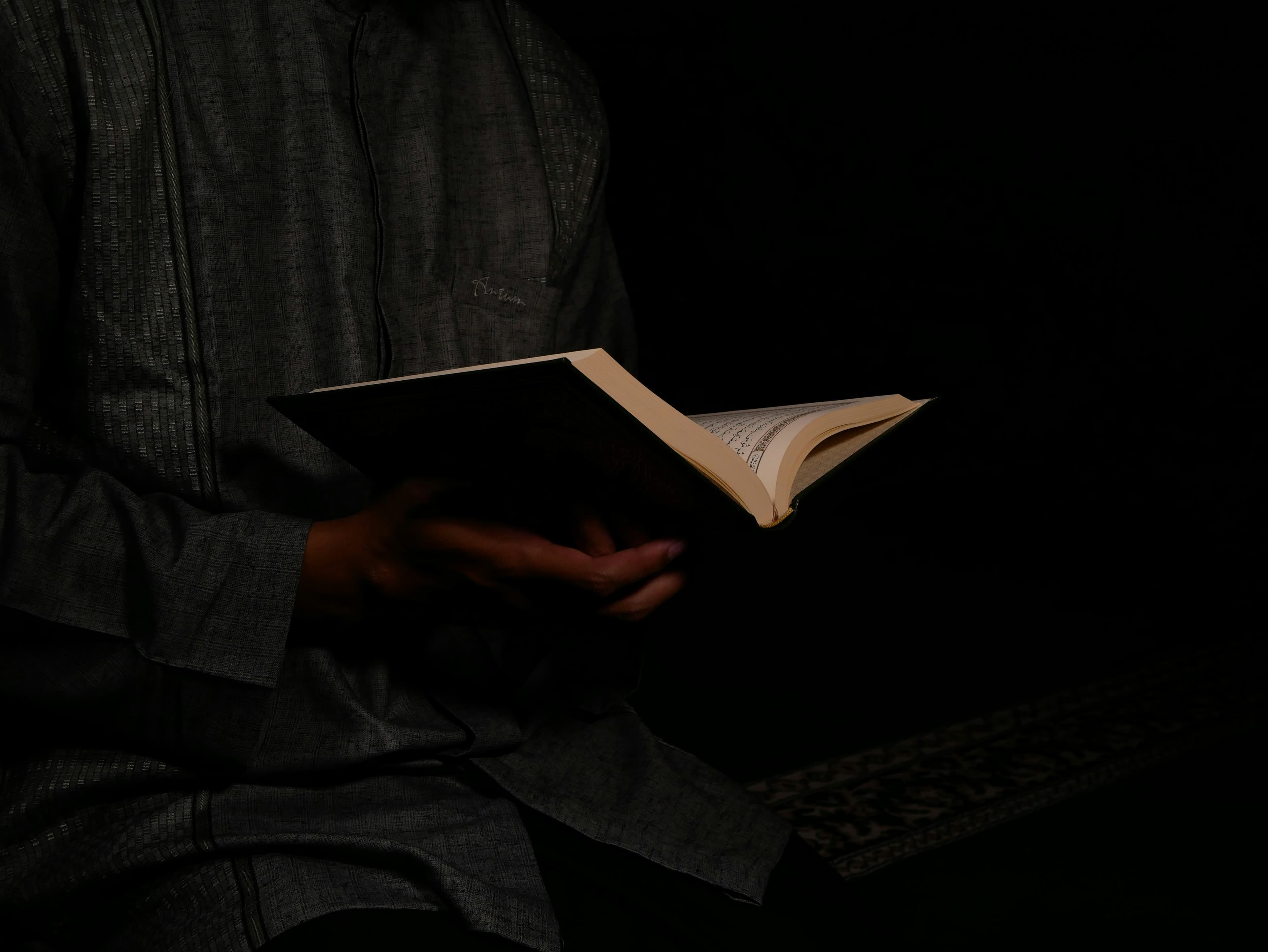 A man reading a book in low light